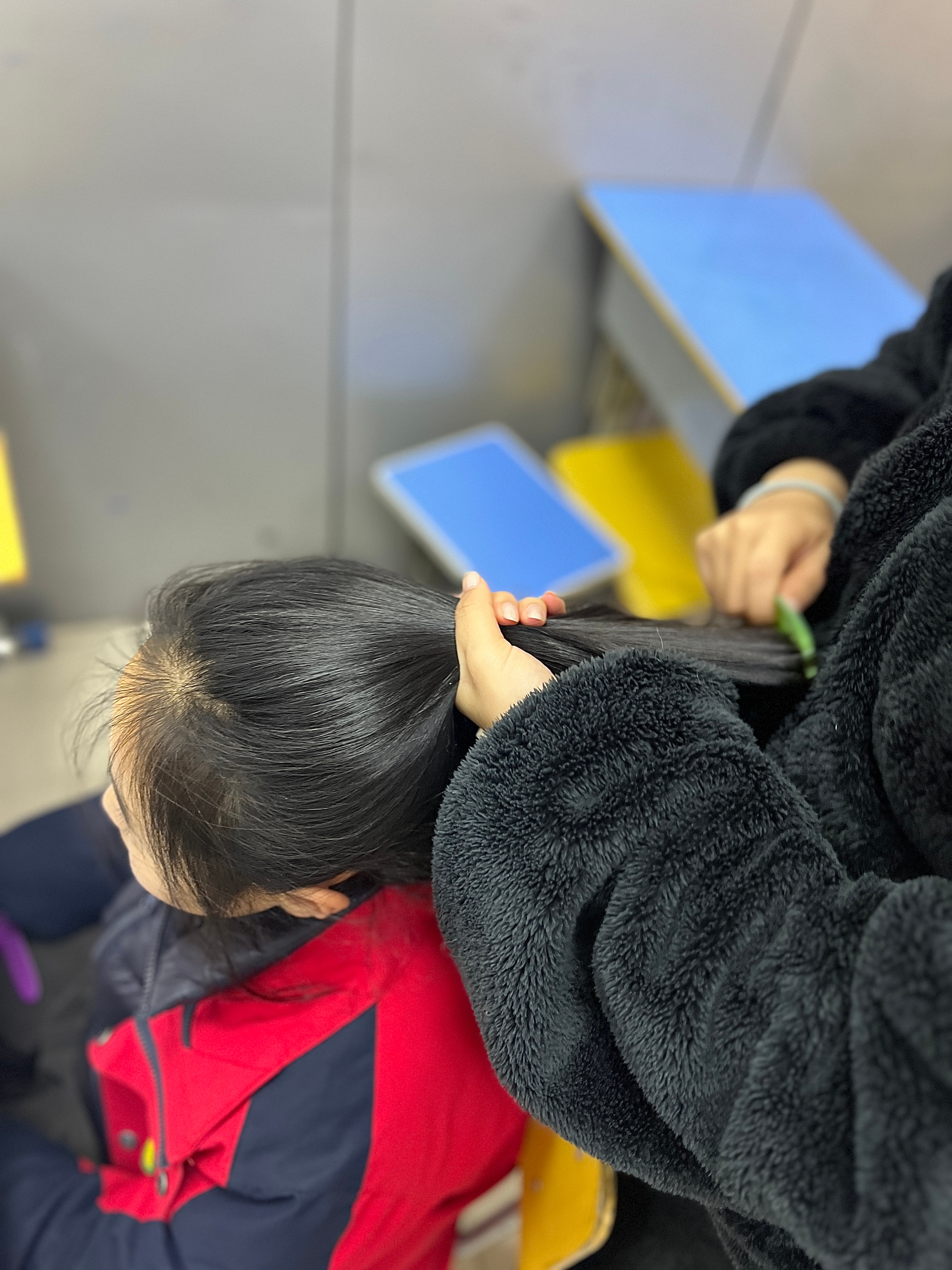 老师巧手梳发，温暖师生情深